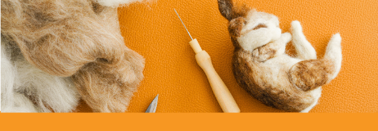 wool, needle and a partially completed needle felt bunny