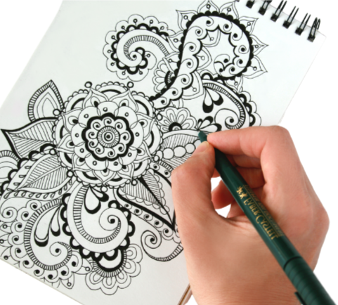 hand drawing a zentangle design in a notebook